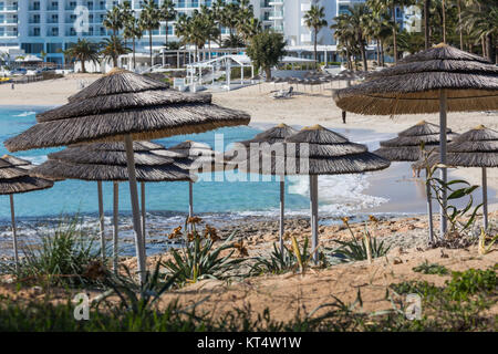 Détail de tissu de parasols au-dessus des rangées de chaises longues et de nombreux lits de détente sur la plage Banque D'Images