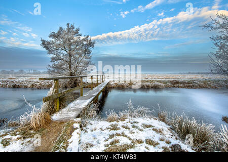 Passerelle sur le canal gelé avec passerelle dans la province de Drenthe aux Pays-Bas sur un matin froid Banque D'Images