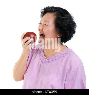 Senior adult woman eating apple Banque D'Images