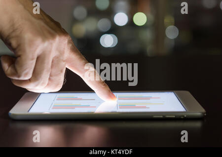 Toucher du doigt sur l'écran tablette avec financial business document. Banque D'Images