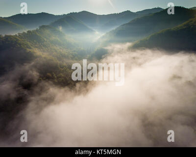 Misty paysage panorama. Rêve fantastique lever du soleil sur les montagnes rocheuses avec vue sur la vallée de Misty ci-dessous. Des nuages de brouillard au-dessus de Forrest. Voir ci-dessous pour paysage féerique. Foggy forest hills.Vue de dessus. Banque D'Images