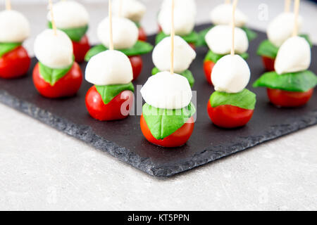 Salade Caprese. Brochettes avec tomate et mozzarella au basilic. Banque D'Images