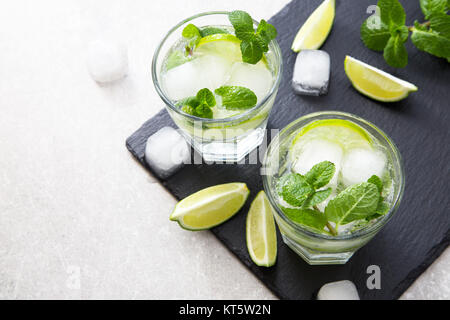 Rempli de limonade d'été mojito dans un verre sur un fond noir en ardoise et du conseil. Banque D'Images