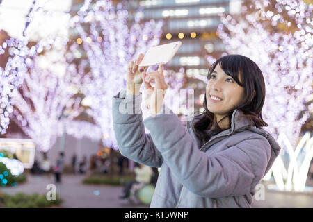 Young Woman taking photo avec décoration de Noël Banque D'Images