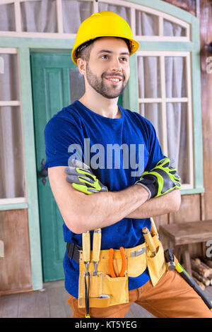 Side view portrait of smiling carpenter en casque avec la création d'outils sur le porche à la voiture Banque D'Images