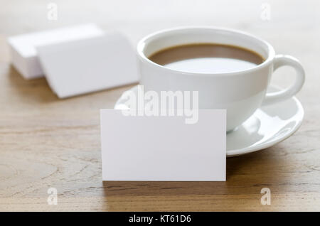 Blank les cartes d'affaires et de tasse de café sur la table en bois. Banque D'Images