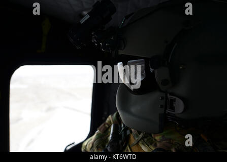 Le s.. Akerson Travis, une des missions spéciales aviator affecté à la 37e Escadron d'hélicoptères à F.E. Warren Air Force Base, Wyo., sondages le paysage que l'équipage se dirige vers la Powder River, complexe de formation dans l'ouest du Dakota du Sud, 7 décembre 2017. L'exercice a fait et autres aviateurs Akerson hélicoptère l'occasion unique de travailler avec les deux au Royaume-Uni, le Royal Air Force de la finale de l'attaque conjointe de contrôleurs et les équipages de bombardiers B-1 d'Ellsworth. (U.S. Air Force Banque D'Images