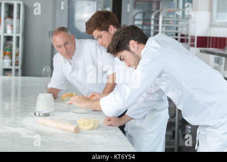 Male pastry concentré avec les apprentis Banque D'Images