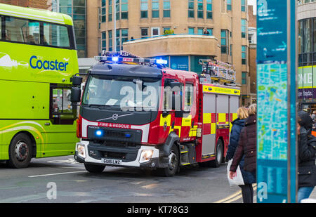 La fire engine avec feux bleus sur un appel à Brighton, East Sussex, Angleterre, Royaume-Uni. Banque D'Images