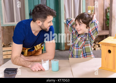 Heureux père et fils en volière et regarder dans l'atelier Banque D'Images