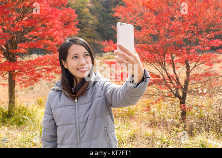 Prendre Femme avec Maple Tree selfies Banque D'Images