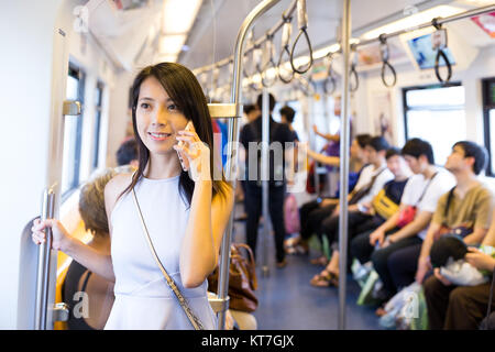 Femme parlant au téléphone cellulaire à l'intérieur du compartiment de train Banque D'Images