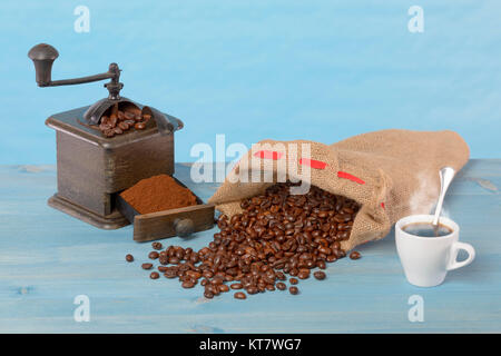 Rectifieuse de café et grains de café dans un sac. Fond bleu. Banque D'Images