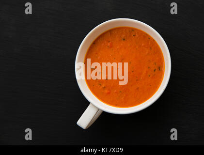 Soupe de crème aux poivrons et tomates sur la plaque noire, vue du dessus Banque D'Images