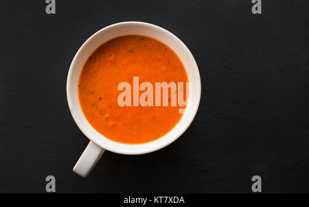 Soupe de crème aux poivrons et tomates sur la plaque noire, vue du dessus Banque D'Images