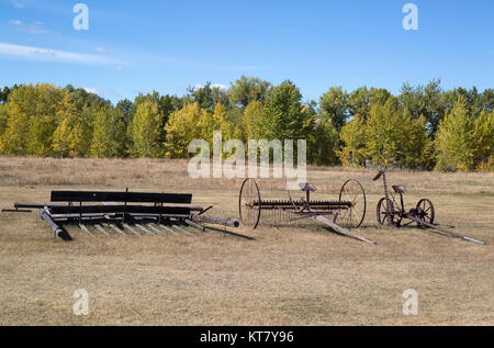 Machines agricoles anciennes, y compris un cultivateur antique rouillé dans un champ au lieu historique national du Ranch-Bar U, Alberta, Canada Banque D'Images