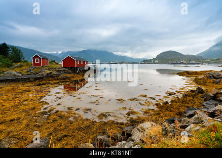 Cabane norvégienne rorbu sur bay coast. Nordic nuageux jour d'été. Banque D'Images