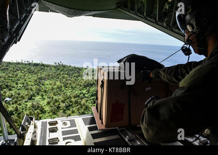 Tech. Le Sgt. Napoléon Ortiz, un C-130J Super Hercules avec le 36ème instructeur loadmaster Escadron de transport aérien, pousse un ensemble de marchandises données à partir de la rampe de chargement d'un C-130J Super Hercules au cours de l'Opération Goutte de Noël, le 11 décembre 2017. Drop est un Noël Pacific Air Forces canadiennes exercice qui comprend un partenariat entre la 374e Escadre de transport aérien, Yokota Air Base, Japon ; la 36e Escadre, Andersen Air Force Base, Guam, le 734e Escadron de la mobilité aérienne, Andersen AFB du 515e aile des opérations de mobilité aérienne, d'une base commune Pearl Harbor-Hickam, New York ; l'Université de Guam, et les partenaires tout au long de Guam. Il Banque D'Images