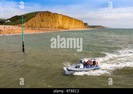 Un Key Largo plein de touristes s'approche de la entrée de West Bay Harbour en face de Falaise est sur la côte jurassique, Dorset, England, UK Banque D'Images