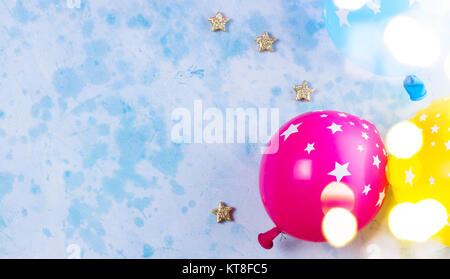 Carnaval de couleurs vives ou partie de ballons sur scène tableau bleu. Mise à plat, de style ou d'un parti d'anniversaire carte de souhaits avec copie espace et lumières bokeh Banque D'Images