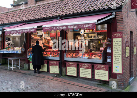 L'achat de viande dame client bien approvisionné de trader sur les bouchers caler au marché de Shambles, une zone de marché historique - York, North Yorkshire, Angleterre, Royaume-Uni. Banque D'Images