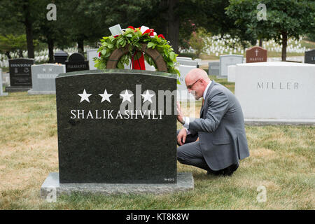 Brent Shalikashvili, fils de l'armée américaine le général John M.D. Shalikashvili, s'agenouille à côté de la pierre tombale le général Shalikashvili après la cérémonie de dépôt par le Ministre géorgien de la Défense Tinatin Khidasheli, Section 30 du Cimetière National d'Arlington, le 18 août 2015. Le général Shalikashvili a été le président de l'état-major des armées de 1993 à 1997 ; il est né en Pologne de parents géorgiens. (U.S. Photo de l'armée par Rachel Larue/libérés) Banque D'Images