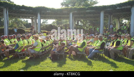 Les bénévoles à l'écoute d'orateurs au cours de la cérémonie d'ouverture de l'Association nationale des professionnels du paysage et de renouvellement annuel des 19e souvenir au Cimetière National d'Arlington, le 16 juillet 2015. Plus de 400 bénévoles ont travaillé sur 200 du cimetière de 624 acres. Une partie des travaux effectués a été paillis, taille, désherbage, plantation, le chaulage et l'application de gypse. (U.S. Photo de l'armée par Rachel Larue/libérés) Banque D'Images