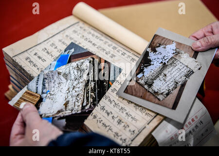 (171222) -- Chengdu, 22 déc., 2017 (Xinhua) -- Dongjue Yuan montre les changements de livres anciens avant et après la réparation, dans la bibliothèque provinciale du Sichuan dans le sud-ouest de Chengdu, capitale de la province chinoise du Sichuan, le 21 décembre 2017. Un Dongjue Yuan, 70 ans, expert de vieux livres de réparations, a continué de travailler sur la réparation et la conservation de livres anciens depuis 1983 en centre de réparation des livres anciens de la bibliothèque provinciale du Sichuan. Dans sa carrière de 34 ans de temps, Yuan a réparé environ 200 livres chinois antiques précieux, certains d'entre eux pourraient remontent à 1 000 ans. Les travaux de réparation se compose de plus de 10 différentes étapes Banque D'Images