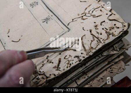 (171222) -- Chengdu, 22 déc., 2017 (Xinhua) -- Dongjue Yuan nettoie une page d'un livre plus de 180 ans, dans la bibliothèque provinciale du Sichuan dans le sud-ouest de Chengdu, capitale de la province chinoise du Sichuan, le 21 décembre 2017. Un Dongjue Yuan, 70 ans, expert de vieux livres de réparations, a continué de travailler sur la réparation et la conservation de livres anciens depuis 1983 en centre de réparation des livres anciens de la bibliothèque provinciale du Sichuan. Dans sa carrière de 34 ans de temps, Yuan a réparé environ 200 livres chinois antiques précieux, certains d'entre eux pourraient remontent à 1 000 ans. Les travaux de réparation se compose de plus de 10 étapes différentes. Pour réparer onl Banque D'Images