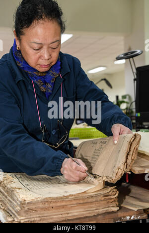 (171222) -- Chengdu, 22 déc., 2017 (Xinhua) -- Dongjue Yuan divise l'un bloque la page d'un livre plus de 180 ans, dans la bibliothèque provinciale du Sichuan dans le sud-ouest de Chengdu, capitale de la province chinoise du Sichuan, le 21 décembre 2017. Un Dongjue Yuan, 70 ans, expert de vieux livres de réparations, a continué de travailler sur la réparation et la conservation de livres anciens depuis 1983 en centre de réparation des livres anciens de la bibliothèque provinciale du Sichuan. Dans sa carrière de 34 ans de temps, Yuan a réparé environ 200 livres chinois antiques précieux, certains d'entre eux pourraient remontent à 1 000 ans. Les travaux de réparation se compose de plus de 10 étapes différentes. À r Banque D'Images