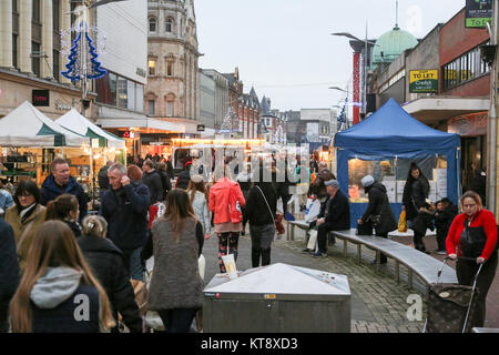 Southend on Sea, Royaume-Uni. 22 décembre 2017. Un marché piétonnier animé illuminé par des lumières festives, avec des gens faisant du shopping, socialisant et se relaxant sur des bancs. La scène présente des étals blancs et bleus à verrière, une architecture historique et des décorations saisonnières, capturant le dynamisme de la vie communautaire dans une ville ou une ville britannique. Avec de nombreux employés payés tôt avant les vacances de Noël, Southend High Street bénéficie d'un début de semaine chargé pour le week-end avant Noël. Crédit : Penelope Barritt/Alamy Live News Banque D'Images