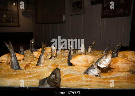 Mousehole, Cornwall, UK. 26Th Dec 2017. Tom Bawcocks Eve. Le légendaire Tom Bawcock sauvé le village de Mousehole de famine en allant à la pêche dans une violente tempête. Pendant le festival une Stargazy pie est faite d'un mélange du poisson, des oeufs et de pommes de terre avec des têtes de poissons et de la queue qui dépasse de la tarte. La tarte est habituellement servi gratuitement dans l'auberge de bateau local. Crédit : Simon Maycock/Alamy Live News Banque D'Images