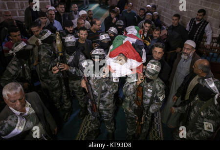 Des membres armés d'Abd al-Qadir al-Husayni brigades, l'une des branches militaires du Fatah, transporter le corps de 29 ans, Mohammed Mohaisen, au cours d'une manifestation enterrement dans la ville de Gaza, bande de Gaza, les territoires palestiniens, le 23 décembre 2017. Un jour plus tôt, Mohaisen a été tué lors d'affrontements avec des soldats israéliens à la suite de protestations contre le président américain, Donald Trump a décidé de reconnaître Jérusalem comme capitale d'Israël. Photo : Wissam Nassar/dpa Banque D'Images