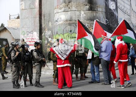 Bethléem, Cisjordanie, territoire palestinien. 26Th Dec 2017. Palestiniens déguisés en père Noël, faire face à la police des frontières israélienne au cours d'une manifestation dans la ville cisjordanienne de Bethléem, Samedi, Décembre 23, 2017. protester contre le président américain Donald Trump' ?s'annonce de reconnaître Jérusalem comme capitale d'Israël et d'un déménagement de l'ambassade américaine de Tel Aviv à Jérusalem : Crédit Hashlamoun Wisam APA/Images/ZUMA/Alamy Fil Live News Banque D'Images