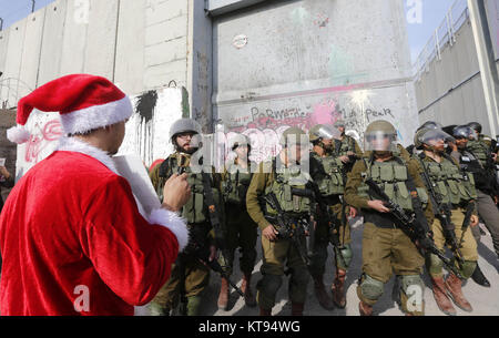 Bethléem, Cisjordanie, territoire palestinien. 26Th Dec 2017. Palestiniens déguisés en père Noël, faire face à la police des frontières israélienne au cours d'une manifestation dans la ville cisjordanienne de Bethléem, Samedi, Décembre 23, 2017. protester contre le président américain Donald Trump' ?s'annonce de reconnaître Jérusalem comme capitale d'Israël et d'un déménagement de l'ambassade américaine de Tel Aviv à Jérusalem : Crédit Hashlamoun Wisam APA/Images/ZUMA/Alamy Fil Live News Banque D'Images