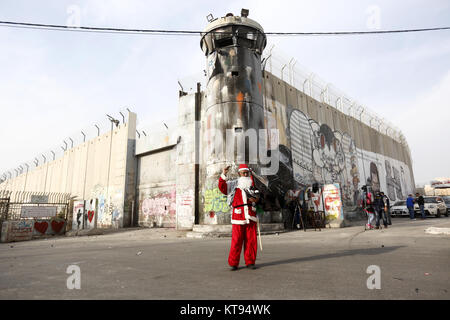 Bethléem, Cisjordanie, territoire palestinien. 26Th Dec 2017. Palestiniens déguisés en père Noël, faire face à la police des frontières israélienne au cours d'une manifestation dans la ville cisjordanienne de Bethléem, Samedi, Décembre 23, 2017. protester contre le président américain Donald Trump' ?s'annonce de reconnaître Jérusalem comme capitale d'Israël et d'un déménagement de l'ambassade américaine de Tel Aviv à Jérusalem : Crédit Hashlamoun Wisam APA/Images/ZUMA/Alamy Fil Live News Banque D'Images