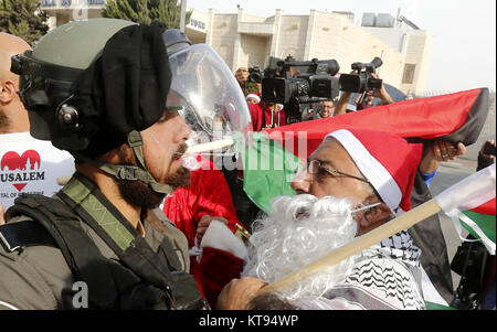 Bethléem, Cisjordanie, territoire palestinien. 26Th Dec 2017. Palestiniens déguisés en père Noël, faire face à la police des frontières israélienne au cours d'une manifestation dans la ville cisjordanienne de Bethléem, Samedi, Décembre 23, 2017. protester contre le président américain Donald Trump' ?s'annonce de reconnaître Jérusalem comme capitale d'Israël et d'un déménagement de l'ambassade américaine de Tel Aviv à Jérusalem : Crédit Hashlamoun Wisam APA/Images/ZUMA/Alamy Fil Live News Banque D'Images