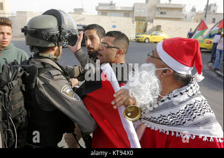 Bethléem, Cisjordanie, territoire palestinien. 26Th Dec 2017. Palestiniens déguisés en père Noël, faire face à la police des frontières israélienne au cours d'une manifestation dans la ville cisjordanienne de Bethléem, Samedi, Décembre 23, 2017. protester contre le président américain Donald Trump' ?s'annonce de reconnaître Jérusalem comme capitale d'Israël et d'un déménagement de l'ambassade américaine de Tel Aviv à Jérusalem : Crédit Hashlamoun Wisam APA/Images/ZUMA/Alamy Fil Live News Banque D'Images