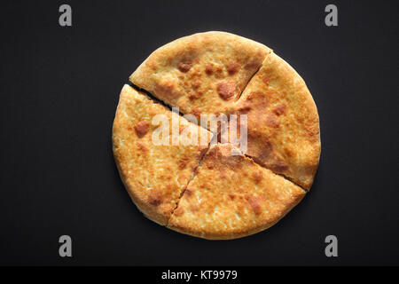 Khachapuri traditionnels sur fond noir en noir Banque D'Images