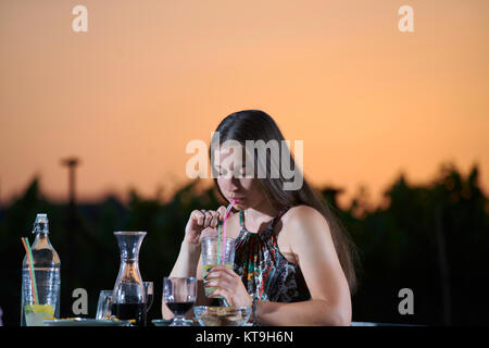 Jeune personne en train de dîner, coucher du soleil Banque D'Images