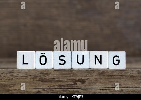 Mot allemand solution, écrit en cubes on a wooden background Banque D'Images