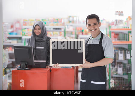 Portrait of happy asian male commerçant avec tableau noir blanc Banque D'Images