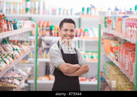 Asian male commerçant debout devant le magasin d'épicerie Banque D'Images