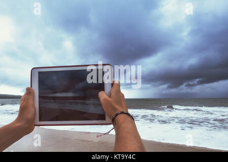 Portrait photo à l'aide de tablet pc mer tempête pendant ses vacances à Bali, Indonésie Banque D'Images