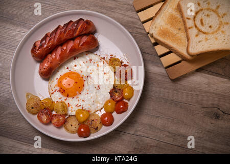 Oeufs brouillés avec saucisses, tomates cerise et l'oignon Banque D'Images