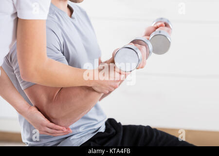 Aider l'homme à l'exercice de l'instructeur Banque D'Images