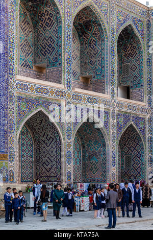 Les écoliers se rendant sur le Sher Dor Madrassa, le Reghistan, Samarkand, Ouzbékistan Banque D'Images