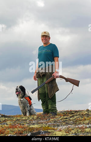 Hunter norvégien avec fusil de chasse chien Setter Anglais et huppée dans la toundra à l'automne, la Norvège Banque D'Images