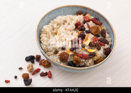 Coupe de l'acier l'avoine servi avec des fruits et des baies séchées Banque D'Images