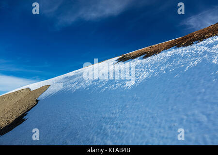 Panorama d'hiver, snow-capped hillside in sunshine sous un ciel nuageux, ciel d'un bleu profond. Un scénario idéal pour tous les sports d'hiver, notamment le ski Banque D'Images